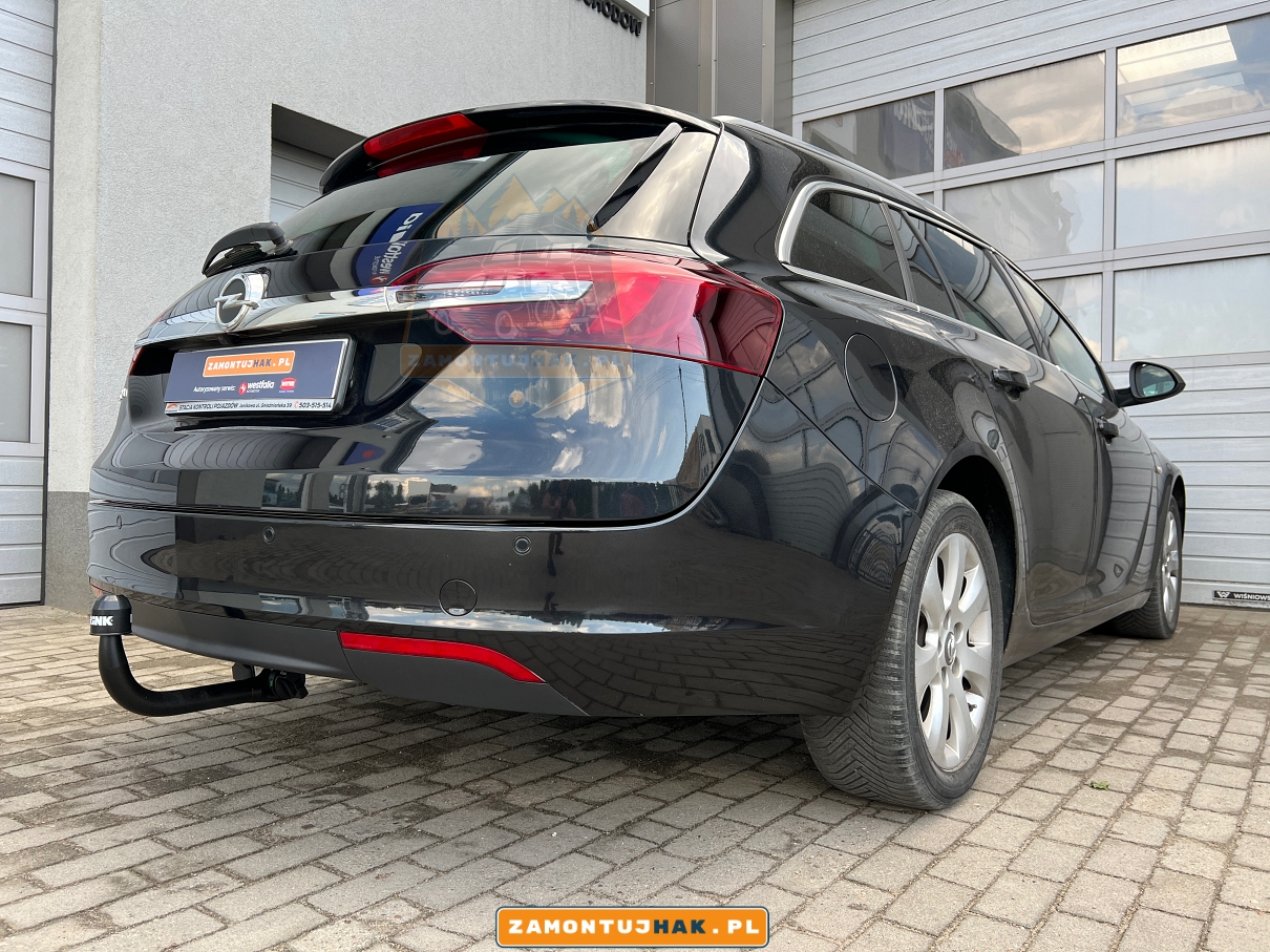 zdjecie samochodu opel insignia kombi 2017 po montazu haka holowniczego z wypinaną kulą holowniczą Brink w serwisie w Poznaniu  na zdjeciu widac samochod z hakiem holowniczym za tylnym zderzakiem samochodu 